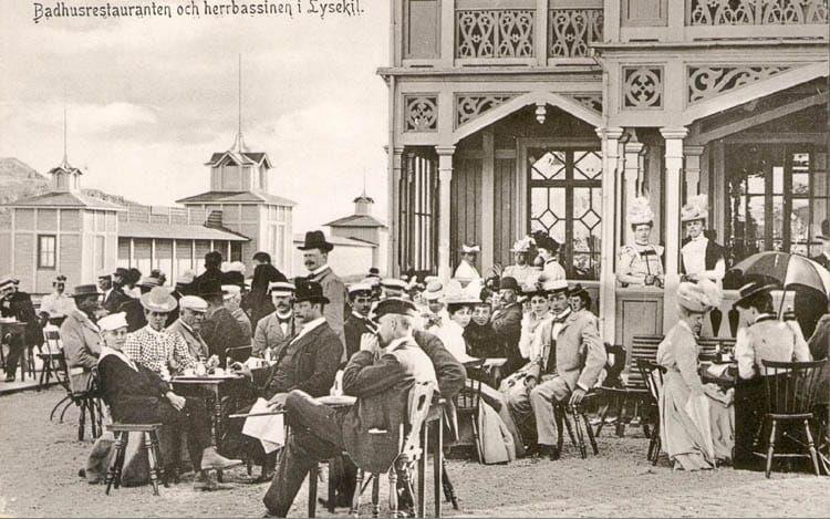 Förfriskningar intages på havsbadrestaurangen i Lysekil. Gästernas kläder och allmänna framtoning tyder på att bilden är tagen i början av 1900-talet. 